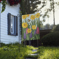 Product mockup of Hand-illustrated spring garden flag design with yellow daffodils, pink and purple hyacinths, green leaves, and a monarch butterfly on a soft blue background