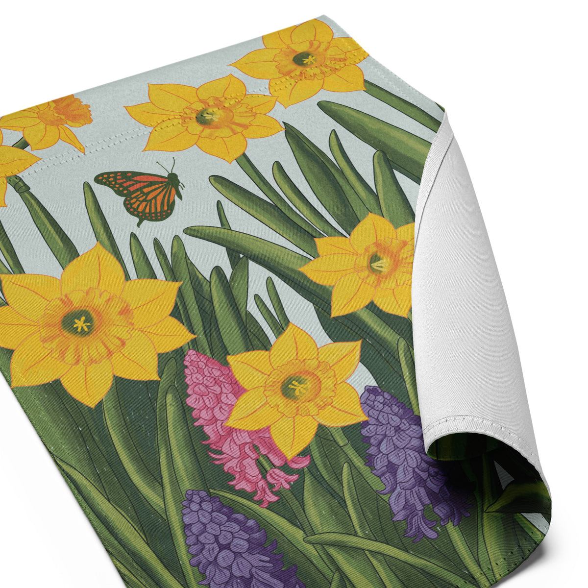 Hand-illustrated spring garden flag design with yellow daffodils, pink and purple hyacinths, green leaves, and a monarch butterfly on a soft blue background